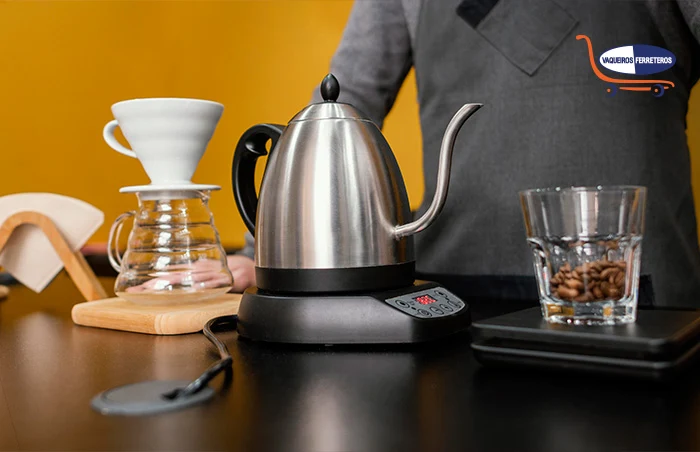 Hombre usando una cafetera eléctrica, vasos y otros objetos sobre una mesa