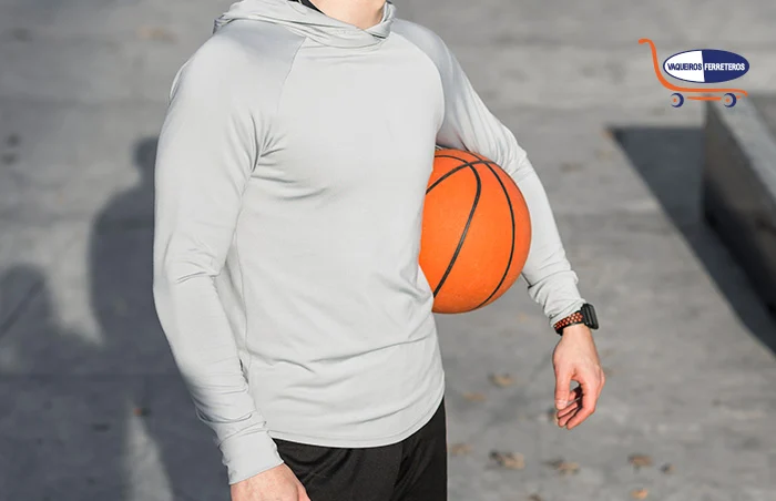 Joven usando una sudadera, con pelota de basketball bajo el brazo